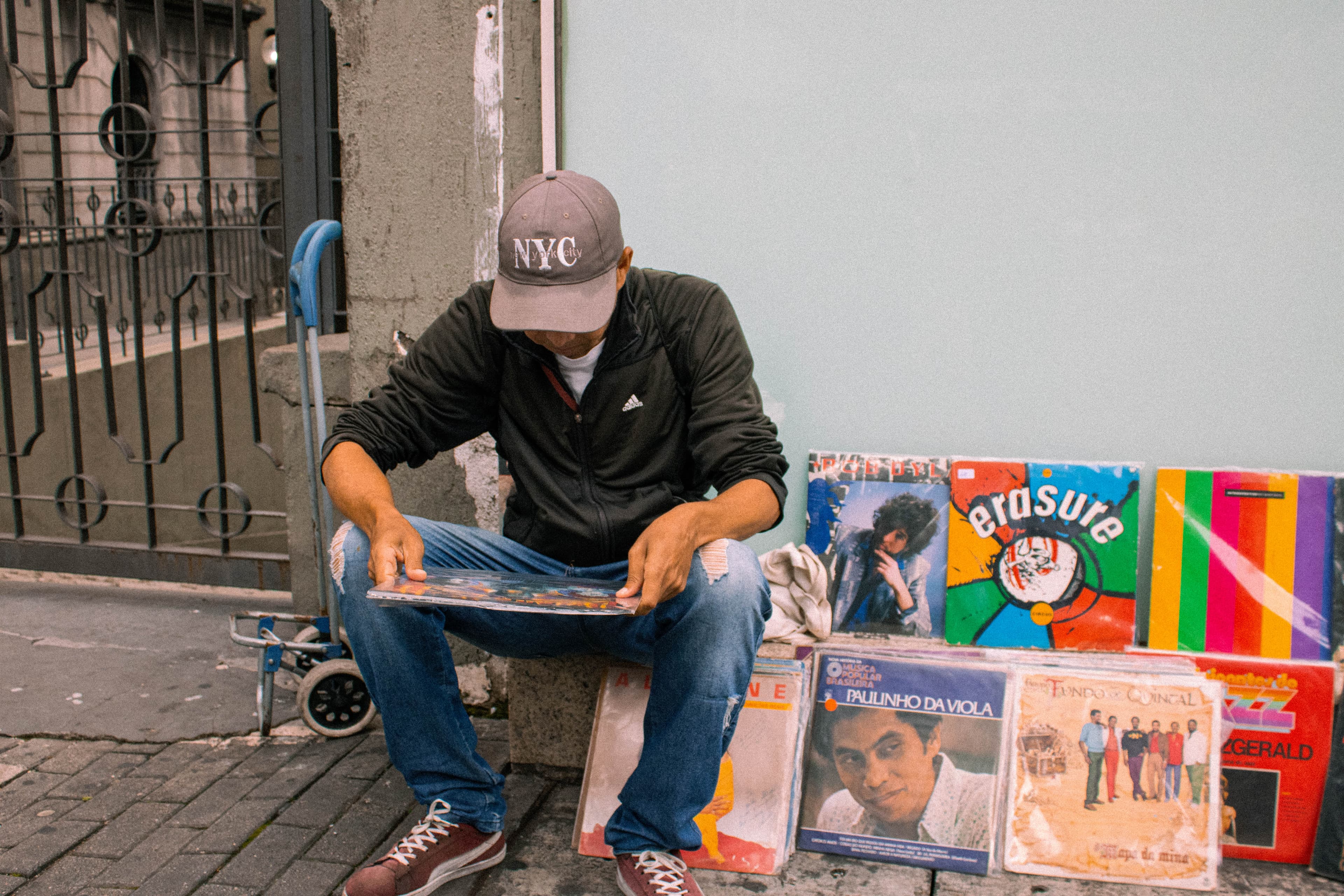 Vendedor ambulante de discos analisando um disco na Av. Paulista.