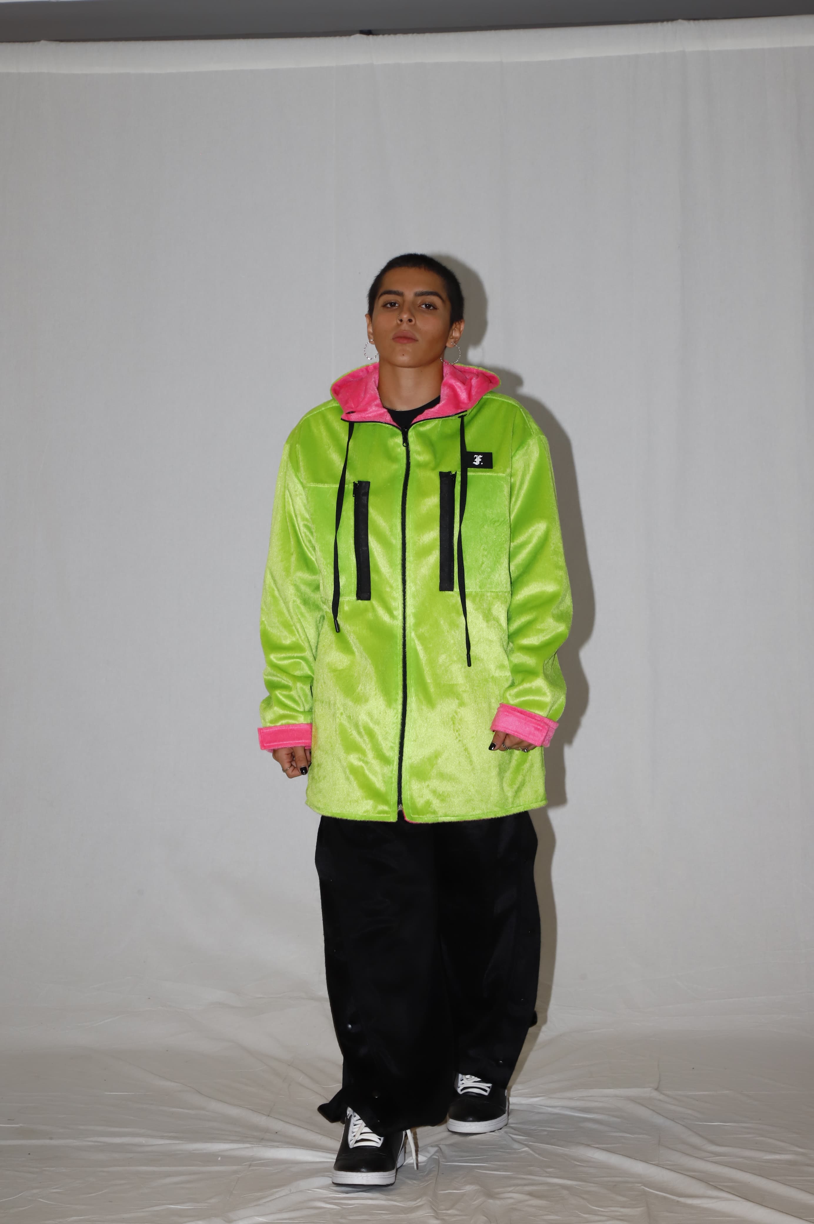 Desfilado com casaco verde no fundo branco.FOAK WEAR