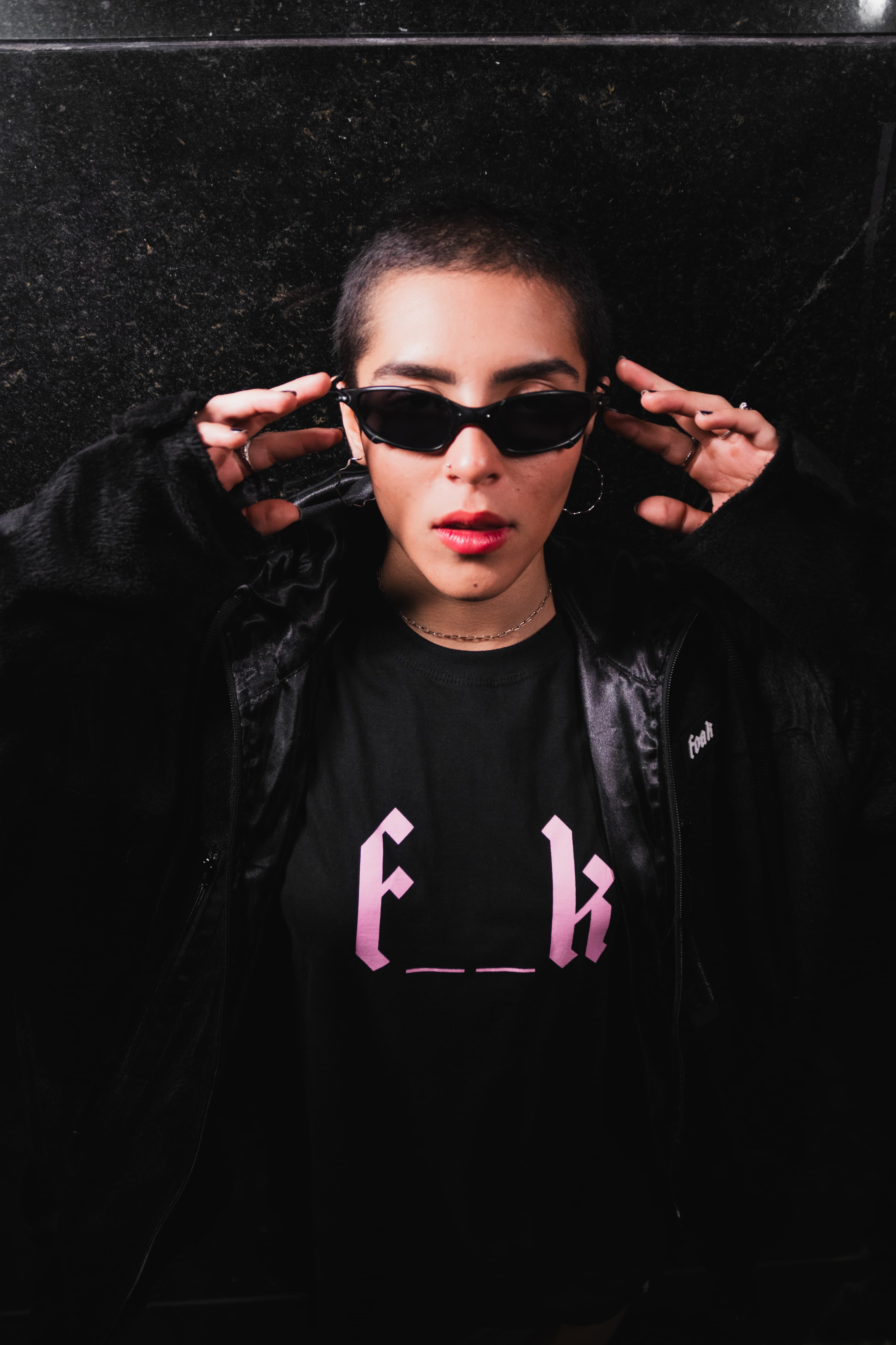 Foto com foco em preto, com óculos preto e indo retirar o óculos