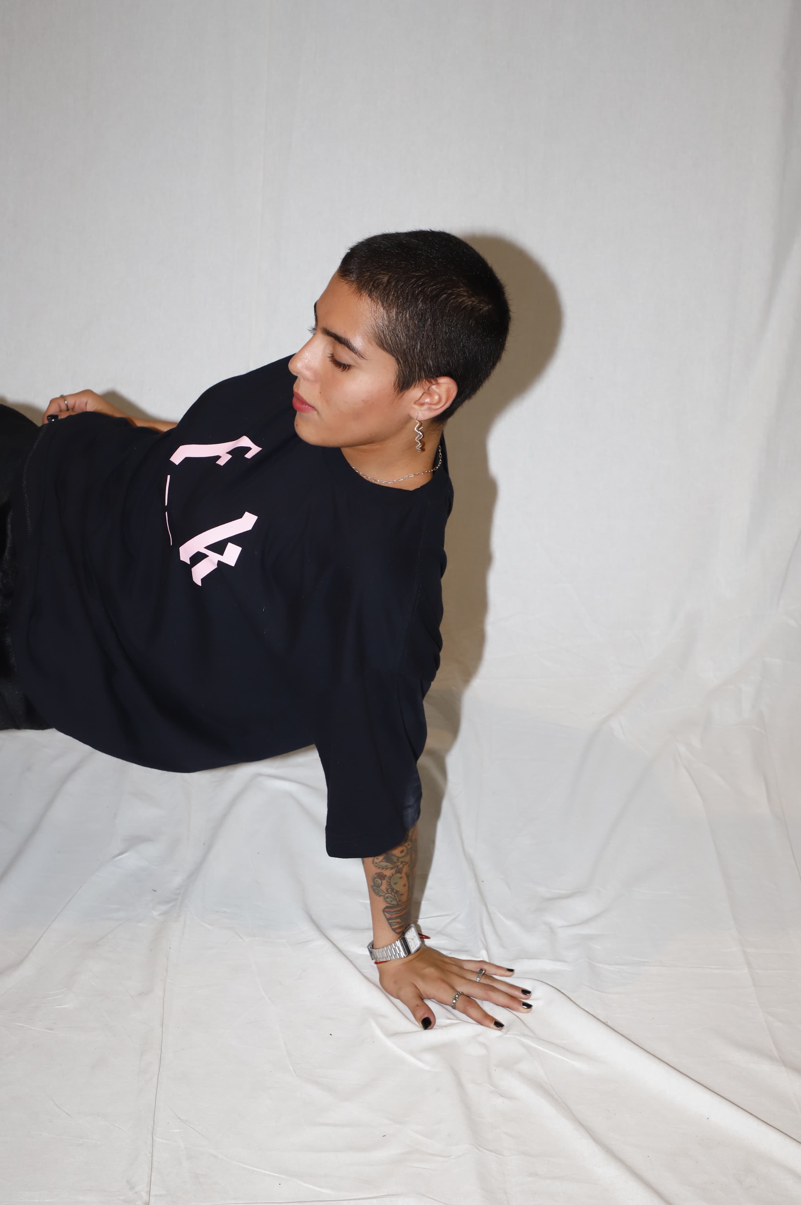 Camiseta Foak Wear Preta. Foto artística com a mão no chão.