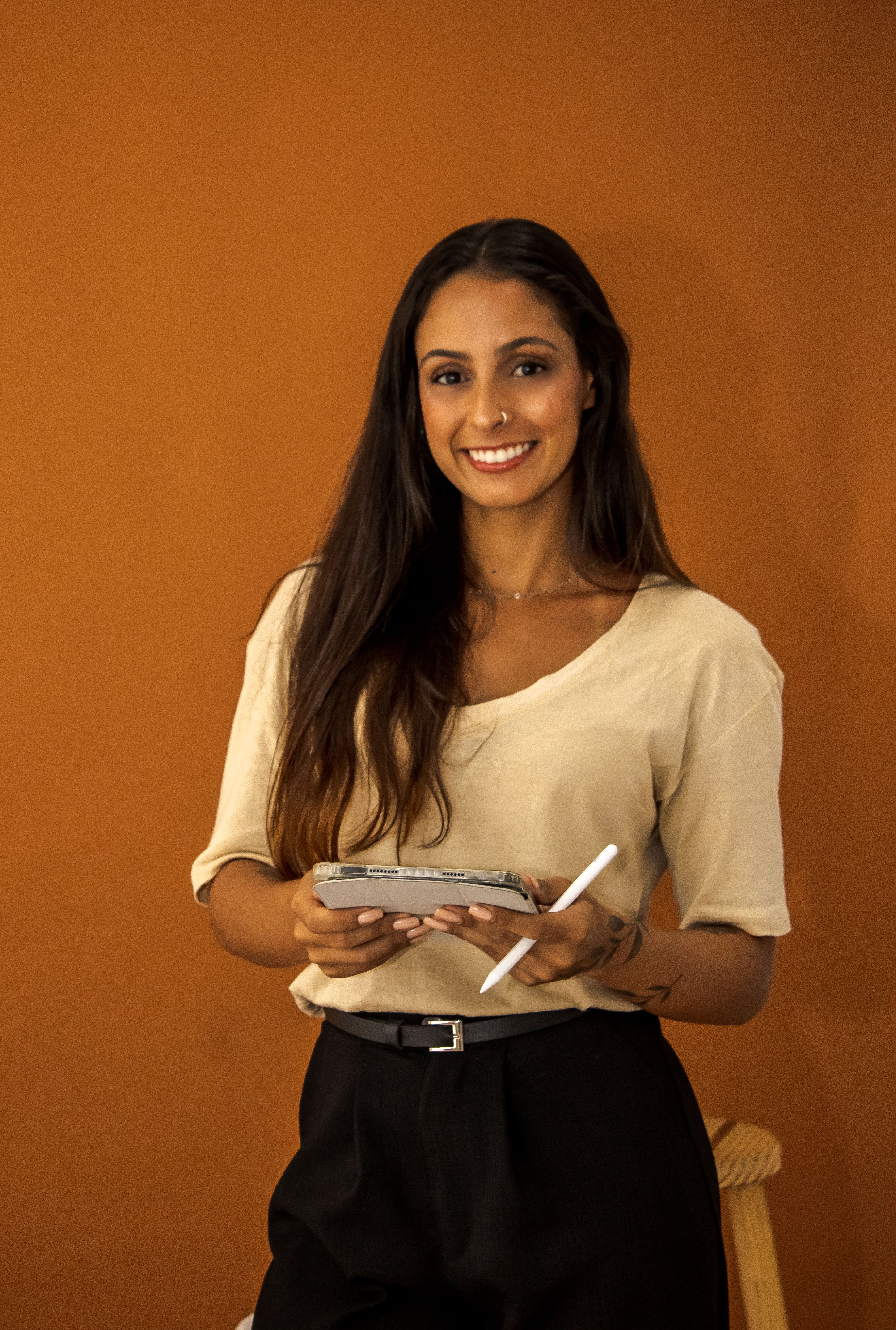 Arquiteta Ana Beatriz Malaquias, posando no fundo terracota 